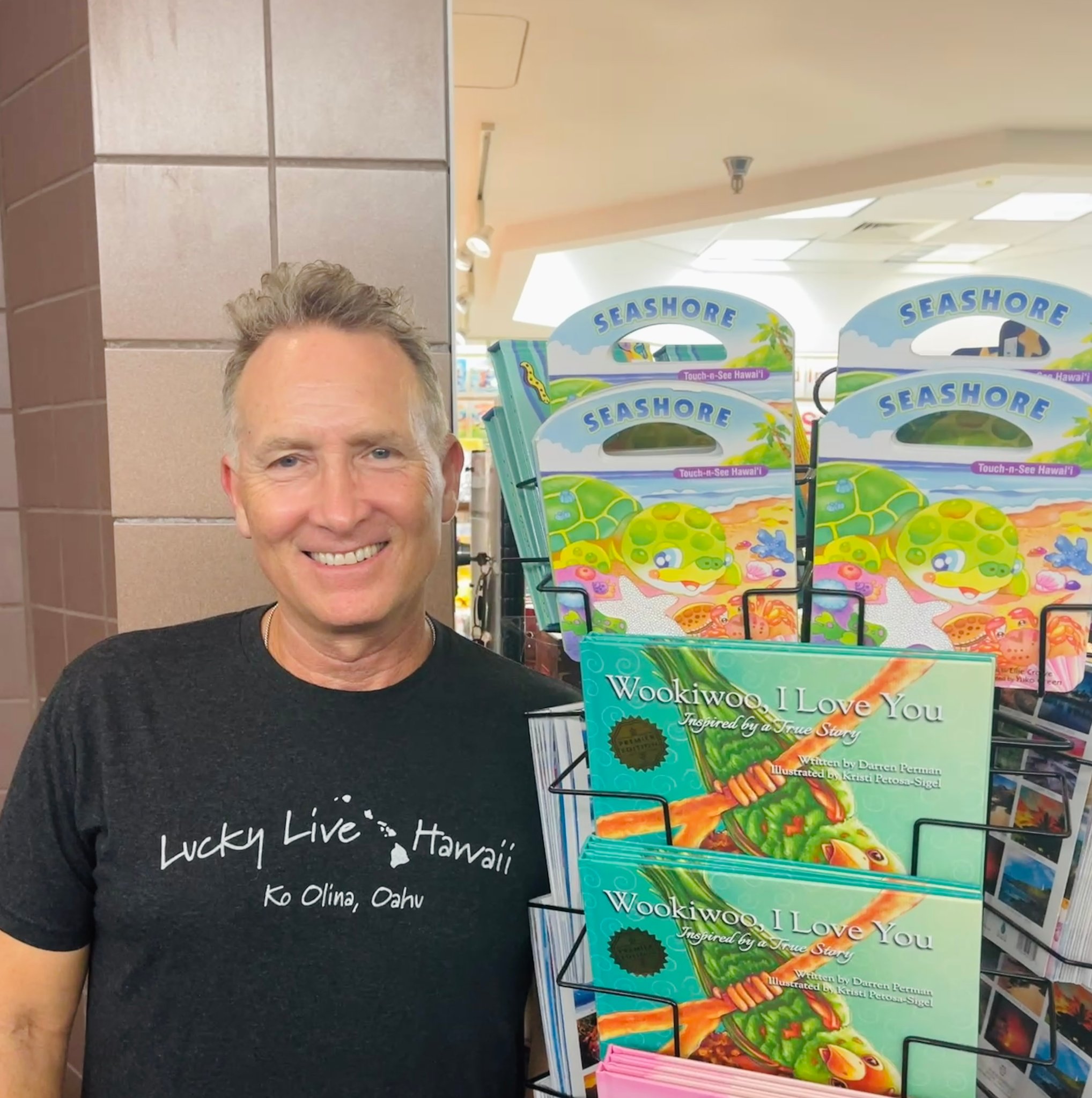 Darren Perman, author of Wookiwoo I Love You, standing next to his books at a store display